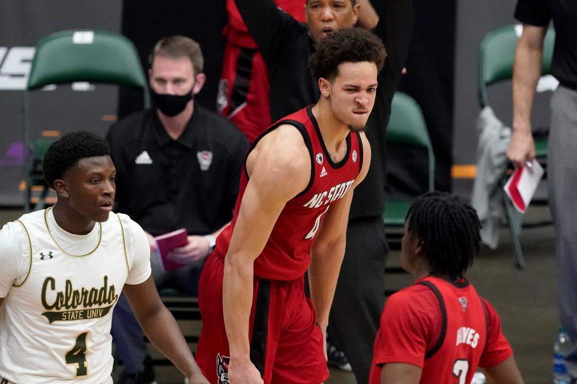 Colorado State guard Isaiah Stevens (4) walks past as North Carolina State forward Jericole Hellems (4) and guard Cam Hayes, right, celebrate a 3-point basket by Hellems late in the second half of an NCAA college basketball game in the quarterfinals of the NIT, Thursday, March 25, 2021, in Frisco, Texas.
