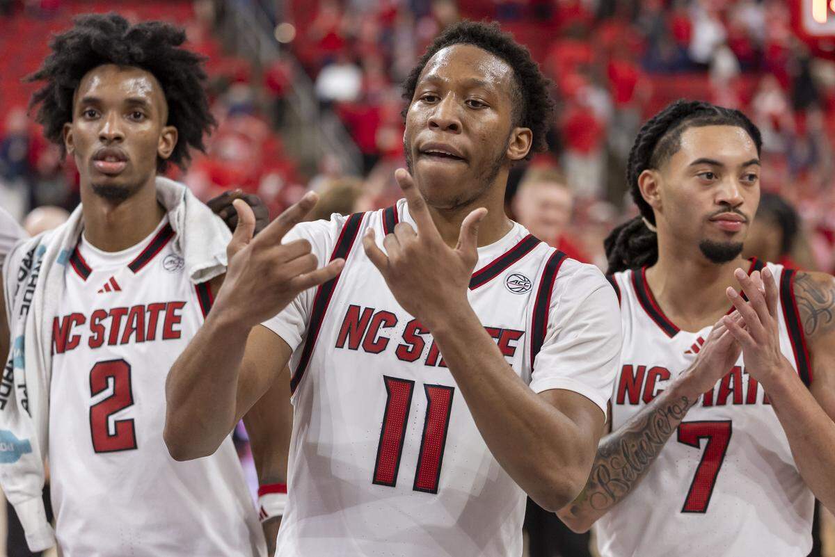 N.C. State’s Quadir Copeland (11) celebrates the Wolfpack’s 82-58 victory over North Carolina with teammates Paul McNeil Jr. (2) and Alyn Breed (7), after singing the Alma Mater on Tuesday, February 17, 2026 at Lenovo Center in Raleigh, N.C. Copeland lead all scores with 20 points. 
