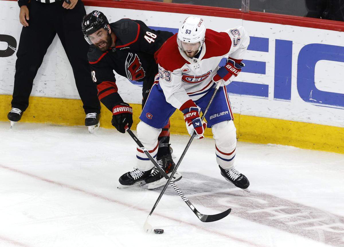 Carolina's Jordan Martinook (48) tries to get the puck from Montréal's Noah Dobson (53) during the second period of the Hurricanes’ game against the Canadiens in game one of the Eastern Conference Finals at the Lenovo Center Thursday, May, 21, 2026.