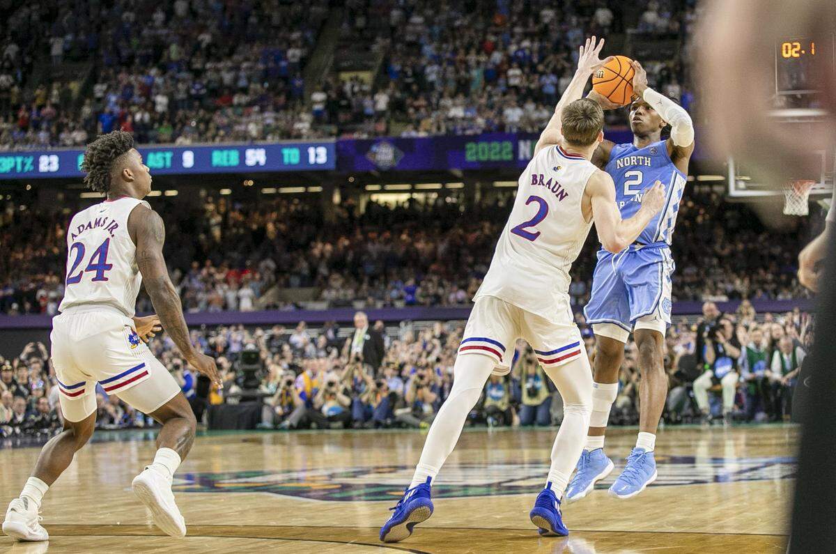 Kansasí Christian Braun (2) defends North Carolinaís Caleb Love (2), as Love launches a three-point shot attempt with 2.1 seconds to play during the NCAA Championship game on Monday, April 4, 2022 at Caesars Superdome in New Orleans, La. Love missed the shot that would have tied the game, securing a 72-69 victory for Kansas.