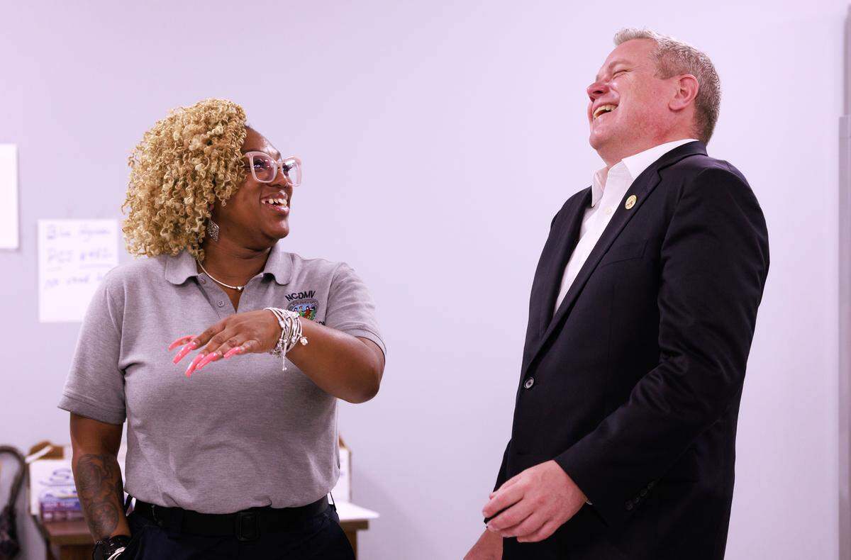 Tanika Williams, a senior examiner at the DMV East Raleigh office, shares a laugh with Commissioner Paul Tine.