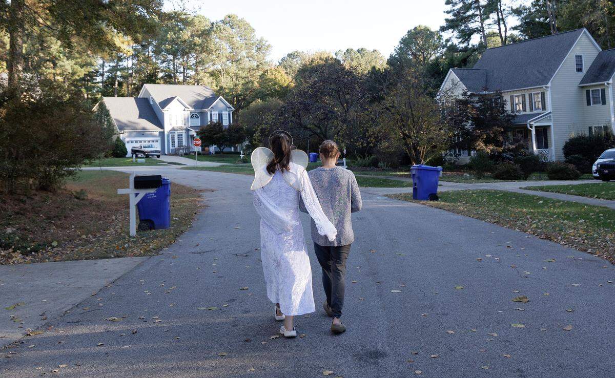 Lexi wears an angel costume as she walks with Krista Caraway in Carrboro prior to attending a Halloween party. 