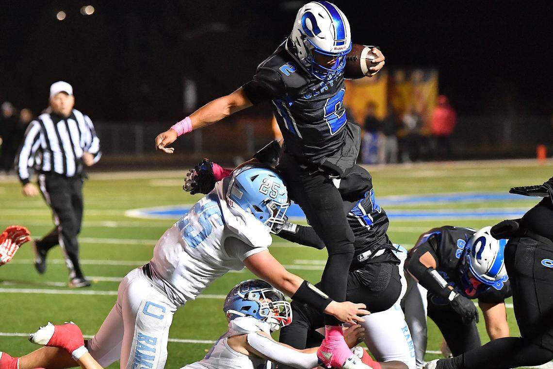 Clayton quarterback Aiden Smalls (2) leaps over the Cleveland defense to gain yards during the second half. The Cleveland Rams took on the Clayton Comets in a conference football game in Clayton, N.C. on October 31st in Clayton, N.C.