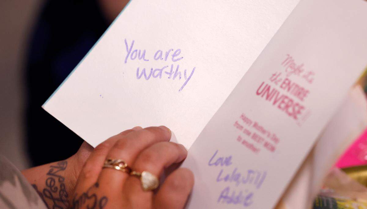 A participant at Healing Transitions in Raleigh opens a card for her during a Mother’s Day tea at the campus Saturday, May 10, 2025.