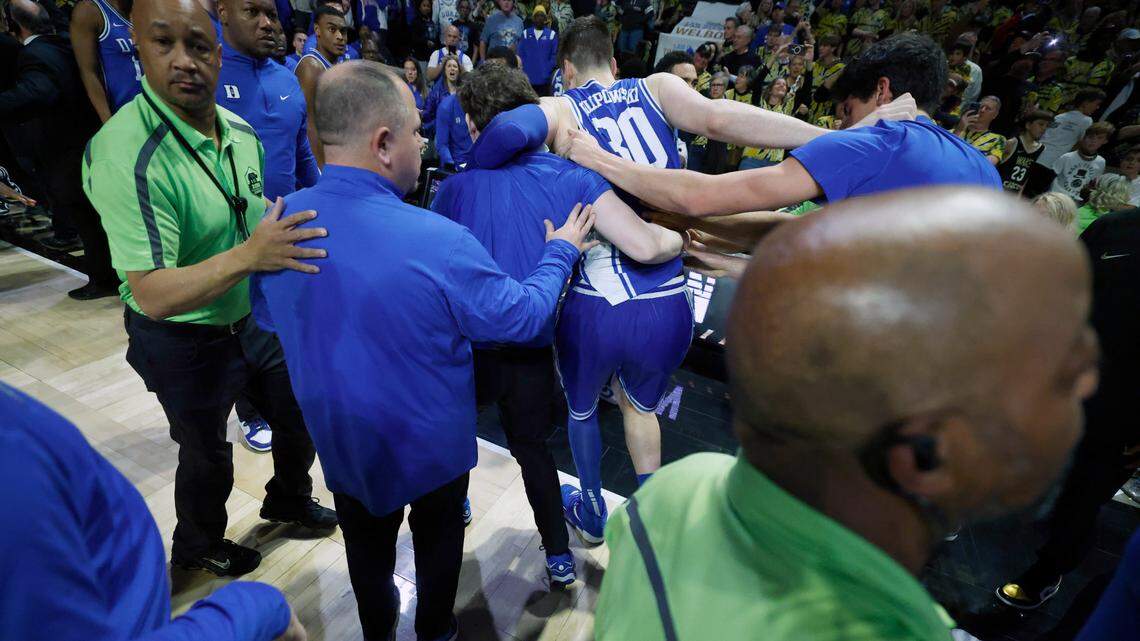 Duke’s Kyle Filipowski (30) is helped off the court after the Wake Forest fans rushed the court after Wake Forest’s 83-79 victory over Duke at Lawrence Joel Veterans Memorial Coliseum in Winston-Salem, N.C., Saturday, Feb. 24, 2024.