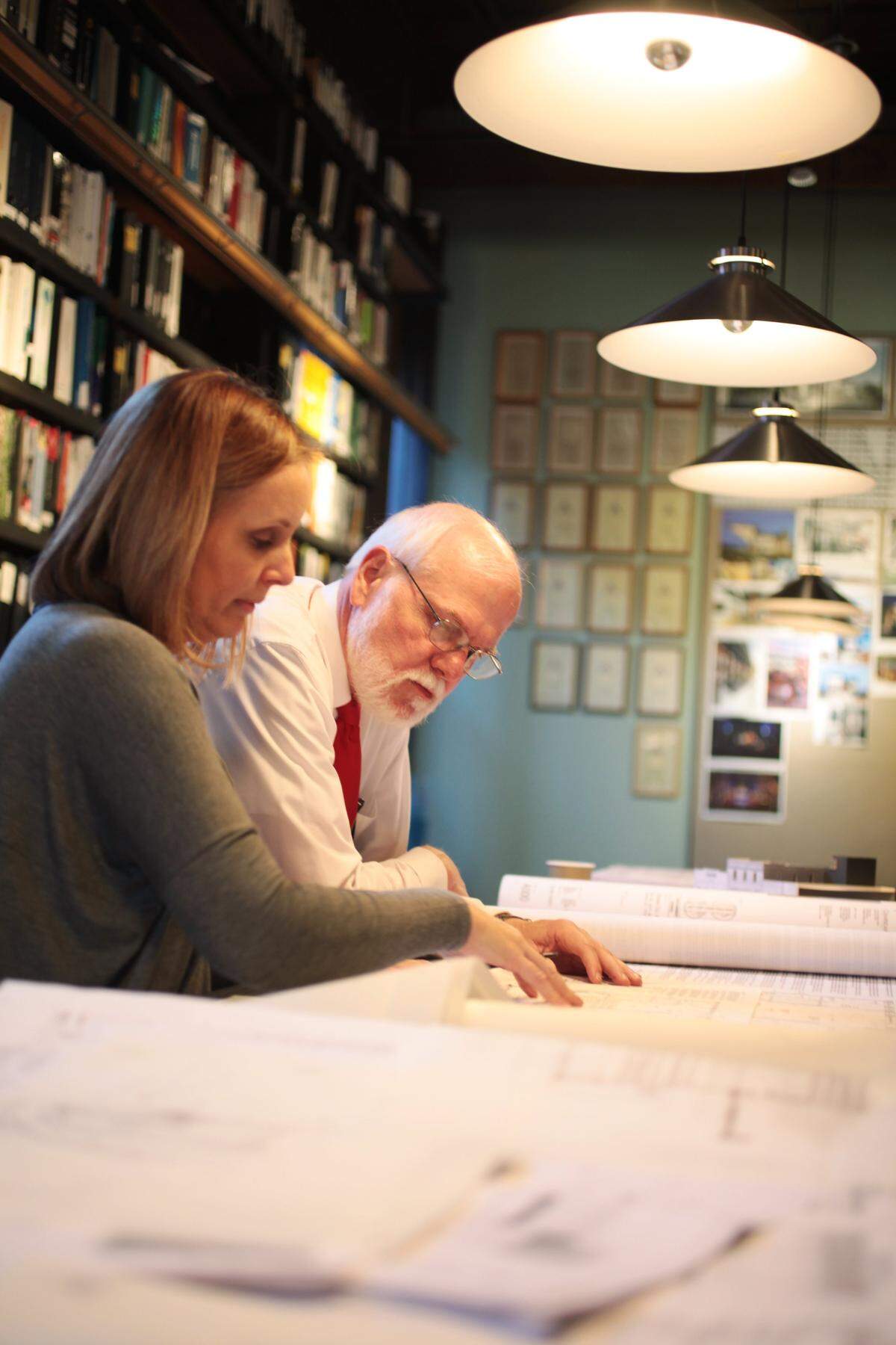 Steve Schuster, right, looks over a project with Clearscapes architect Elizabeth Caliendo, left, December 16, 2014, at Clearscapes in downtown Raleigh. He often refers to the Clearscapes’ staff as “doing the hard work” while he conducts meetings.