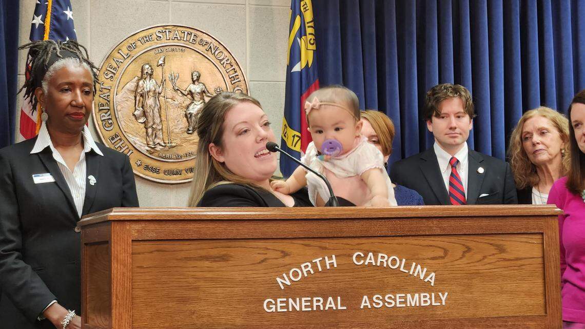 Daphne Alsiyao, holding her 8-month-old daughter Ella Rose, talked about the child care crisis during a news conference March 9, 2023, at the Legislative Building in downtown Raleigh, N.C.