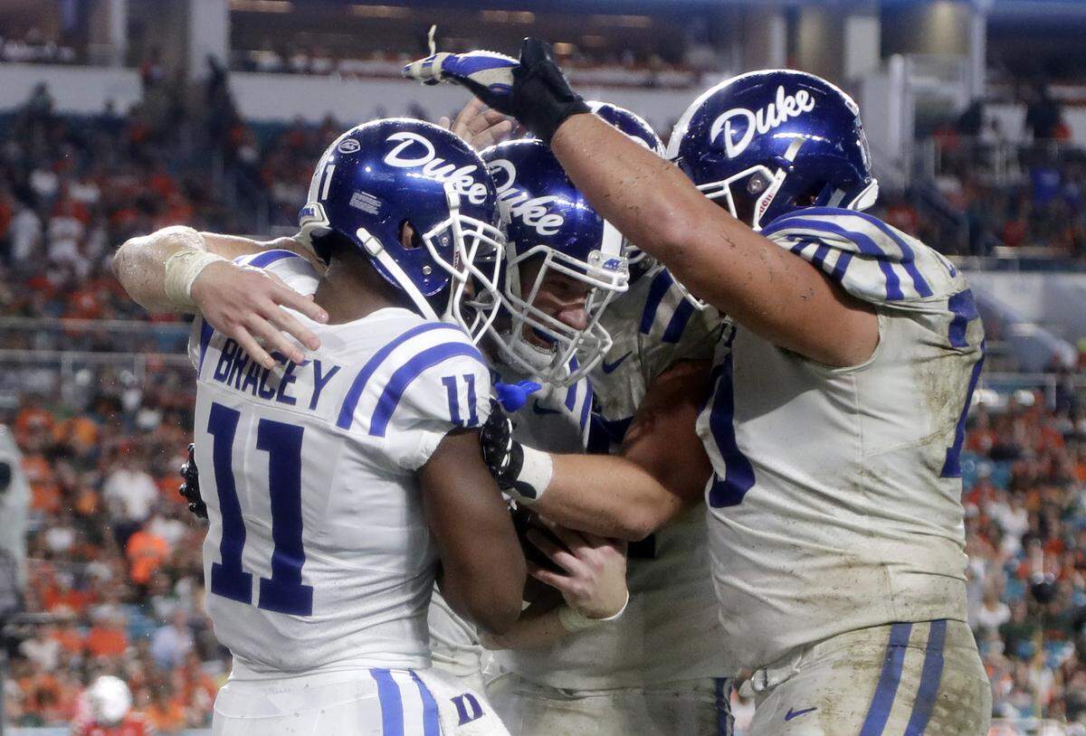 Duke tight end Daniel Helm, second from left celebrates with wide receiver Scott Bracey (11) after scoring a touchdown during the second half.