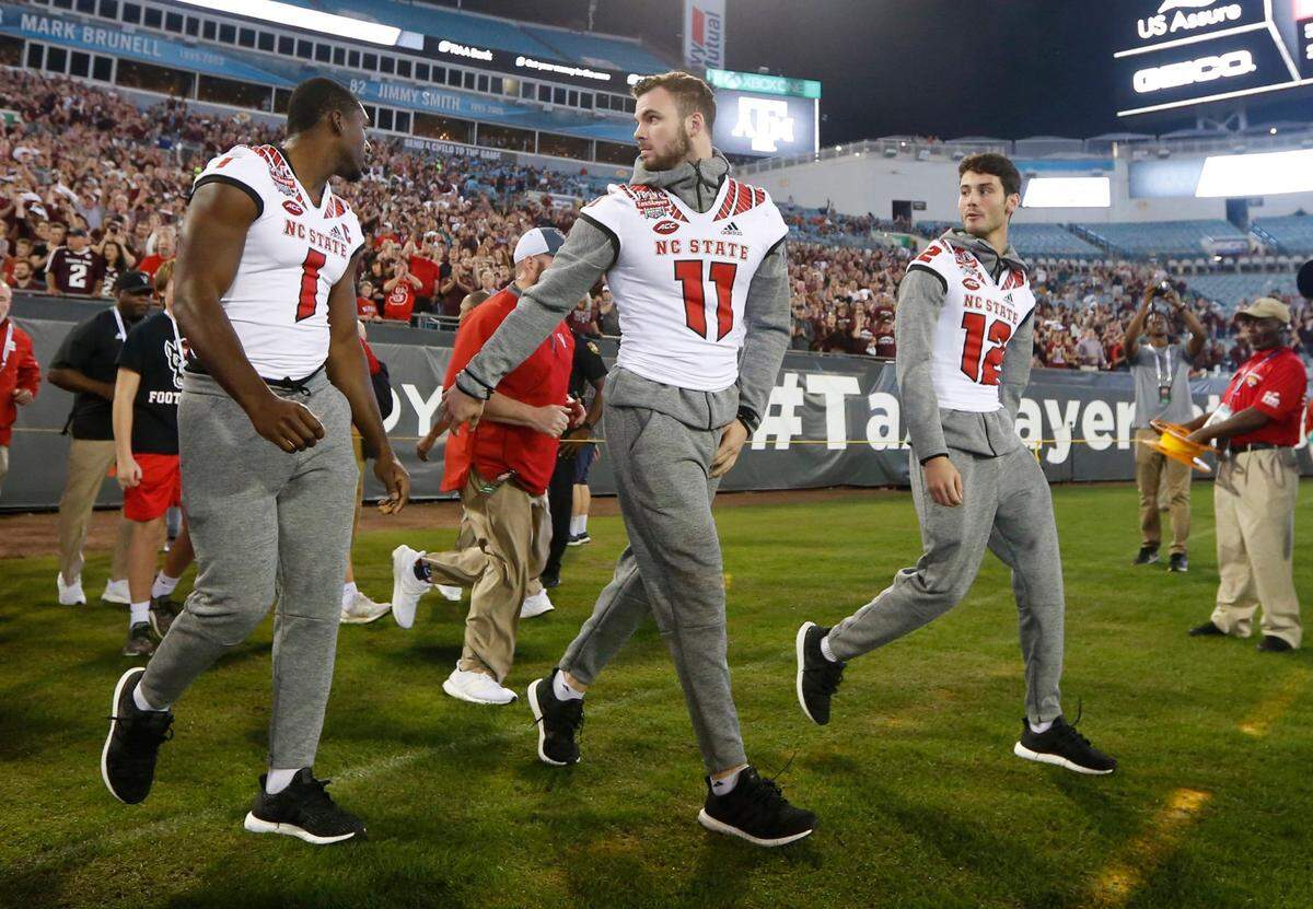From left, N.C. State’s Stephen Louis (1) Payton Wilson (11), and Jory Perkins (12) walk onto the field before the Wolfpack’s game against Texas A&M in the TaxSlayer Gator Bowl at TIAA Bank Field in Jacksonville, Fla., Monday, Dec. 31, 2018.