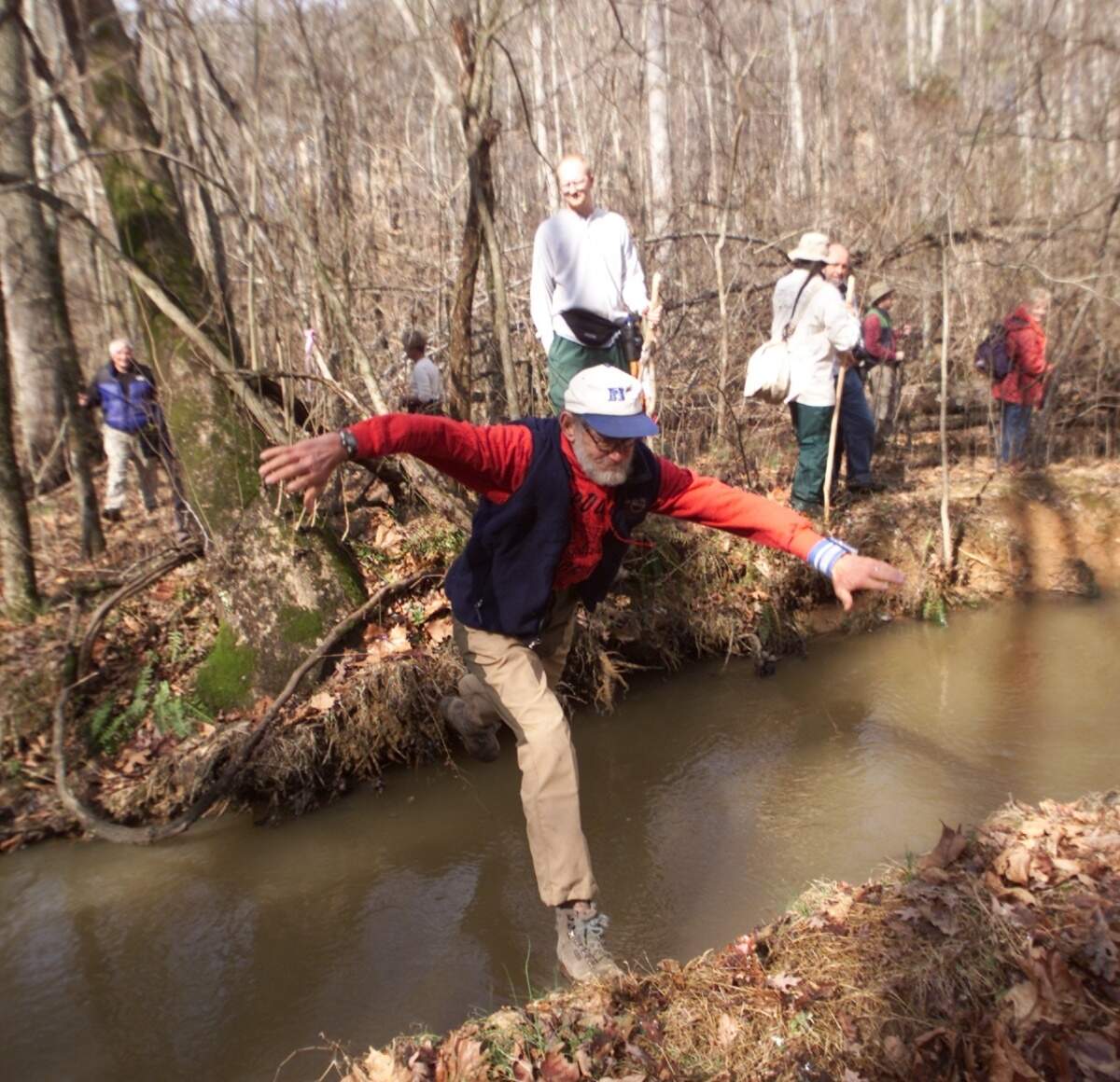 Duke biology professor Peter Klopfer jumps a creek just off New Hope Church Road as he participates in a reenactment hike from the reconstructed Occaneechi village in present-day Hillsborough to the town of Adshusheer near present-day Durham.