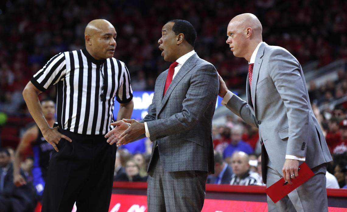 N.C. State assistant coach A.W. Hamilton listens as coach Kevin Keatts talks with official Bill Covington Jr. during the Wolfpack's game against Duke at PNC Arena in Raleigh, N.C., Saturday, Jan. 6, 2018.