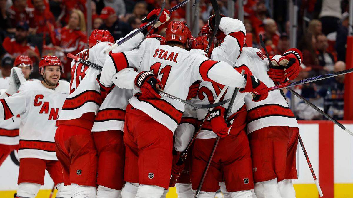Carolina Hurricanes defenseman Jaccob Slavin (74) celebrates with teammates after scoring the game winning goal against the Washington Capitals in overtime in game one of the second round of the 2025 Stanley Cup Playoffs at Capital One Arena. 