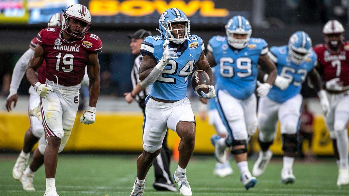 North Carolina’s British Brooks (24) races 63 yards for a touchdown in the second quarter against South Carolina in the Duke’s Mayo Bowl on Thursday, December 30, 2021 at Bank of America Stadium in Charlotte, N.C.