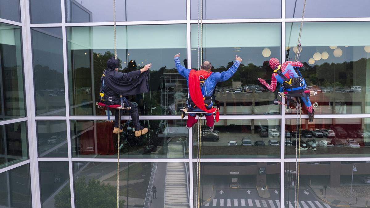 Window washers dressed as superheroes Batman, Superman and Spider-Man cheer on patients at WakeMed Children’s Hospital as they rappel down the building during a Superhero Surprise event Tuesday, April 28, 2026.