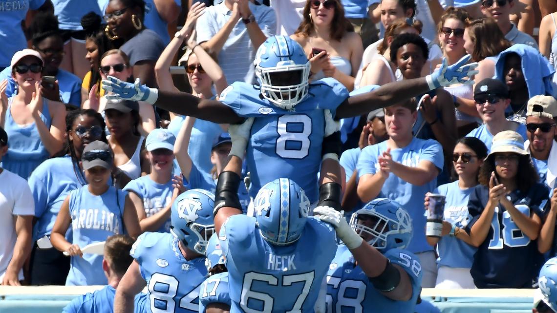 UNC running back Michael Carter (8) is held aloft by teammate offensive tackle Charlie Heck (67) after scoring a touchdown in the second quarter. UNC played Pittsburgh in Chapel Hill, N.C. Saturday, Sept.22, 2018.