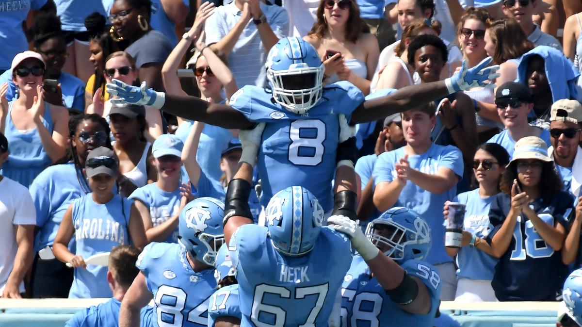 UNC running back Michael Carter (8) is held aloft by teammate offensive tackle Charlie Heck (67) after scoring a touchdown in the second quarter. UNC played Pittsburgh in Chapel Hill, N.C. Saturday, Sept.22, 2018.