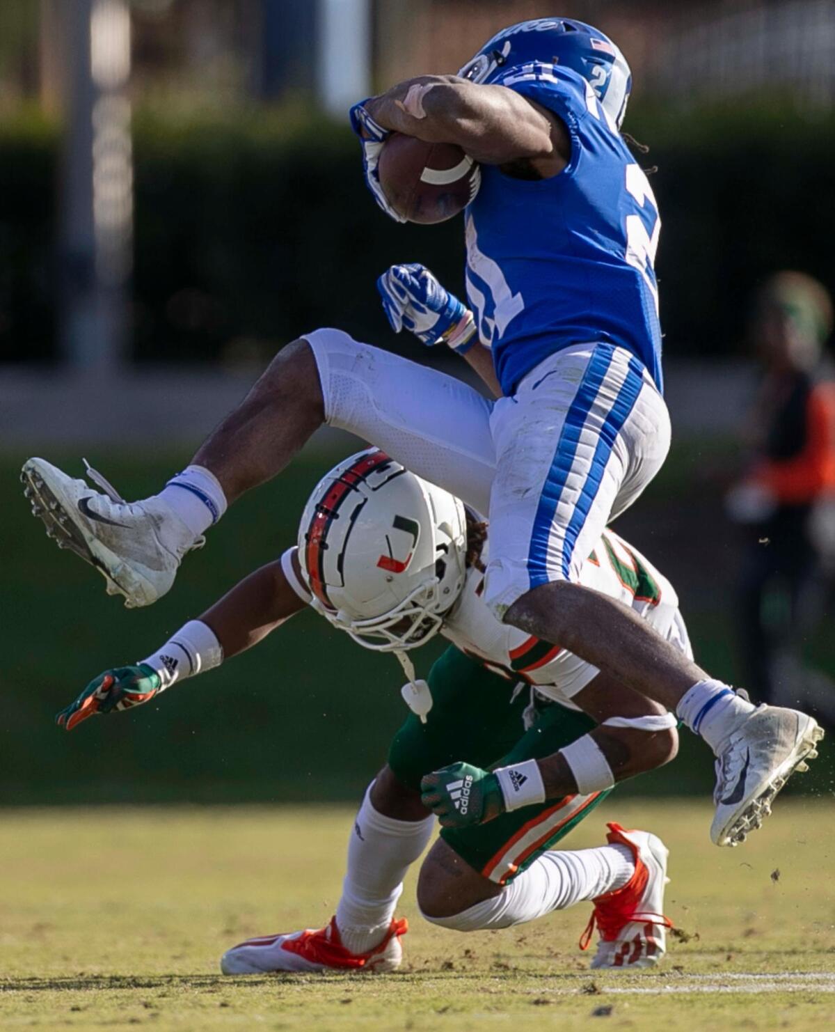 Duke’s Mataeo Durant (21) hurdles over Miami’s Marcus Clarke (26) after a two yard gain in the third quarter on Saturday, November 27, 2021 at Wallace Wade Stadium in Durham, N.C.