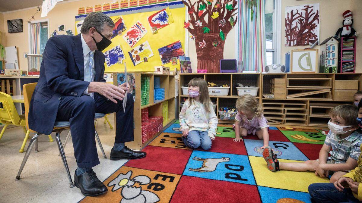 Gov. Roy Cooper reads to children at the Community School for People Under Six in Carrboro, N.C. on Thursday, Oct. 7, 2021.