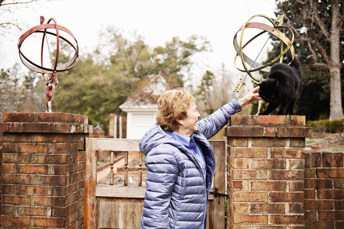Author Frances Mayes pets one of her cats in the rose garden at her Hillsborough home on Thursday, March 7, 2019.
