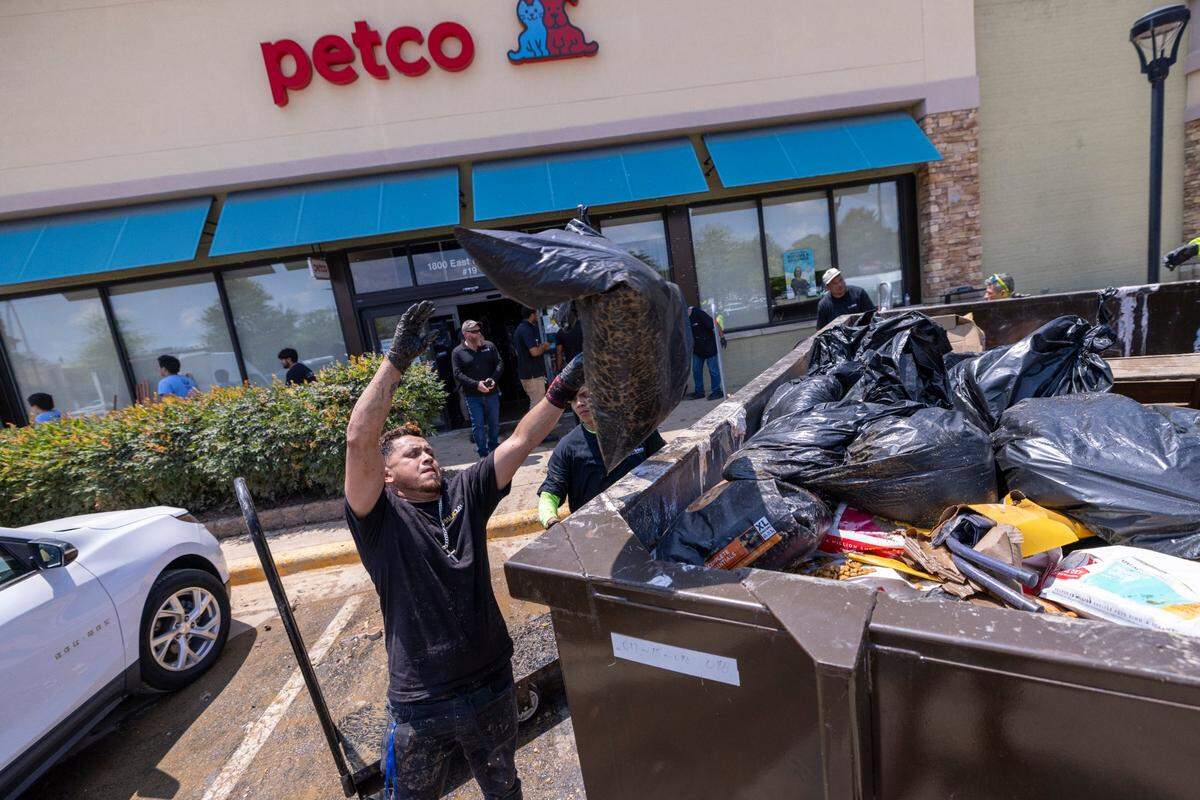 Workers discard thousands of dollars worth of flooded pet food and supplies at a Petco in Eastgate Crossing in Chapel Hill on Monday, July 7, 2025, after floodwaters surged about 5 feet inside businesses at the shopping center. The flooding was caused by heavy rain from Tropical Storm Chantal, which triggered flash flooding in parts of Orange, Durham, and Chatham counties.