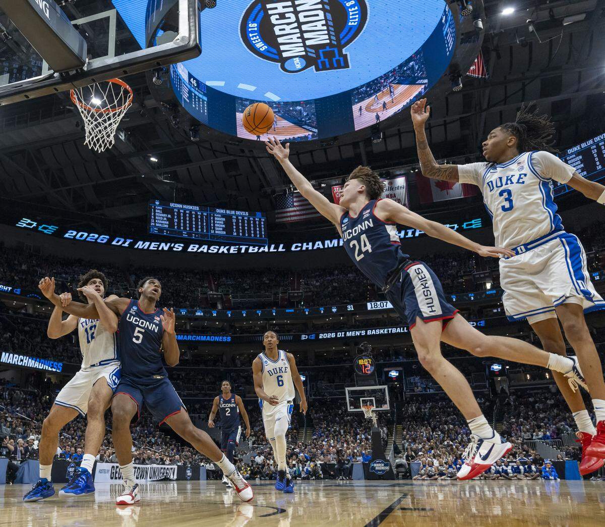 Connecticut guard Braylon Mullins (24) breaks to the basket against Duke forward Isaiah Evans (3) in the second half on Sunday, March 29, 2026, in the NCAA East Regional Championship, at Capital One Arena in Washington, 