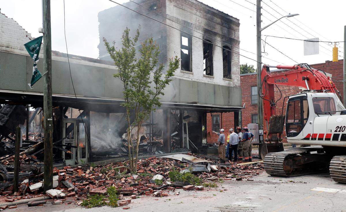 Firefighters and investigators look over what is left after a fire destroyed what is believed to be an over 100-year-old building on Main Street in downtown Warrenton, N.C., Friday, May 29, 2020. The building was the home of Milano’s Italian Restaurant.