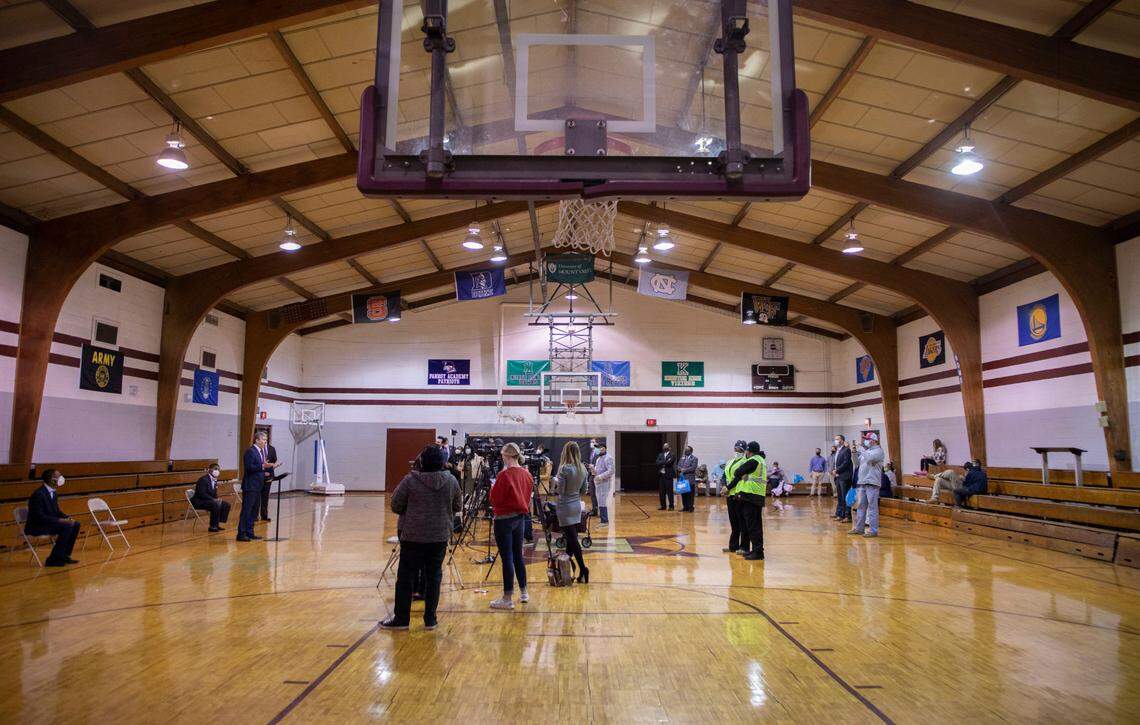 Governor Roy Cooper and local government officials speak to reporters in the gym at Holloway Community Center in Kinston, N.C. during a COVID-19 vaccination and testing event on Jan. 13, 2022.