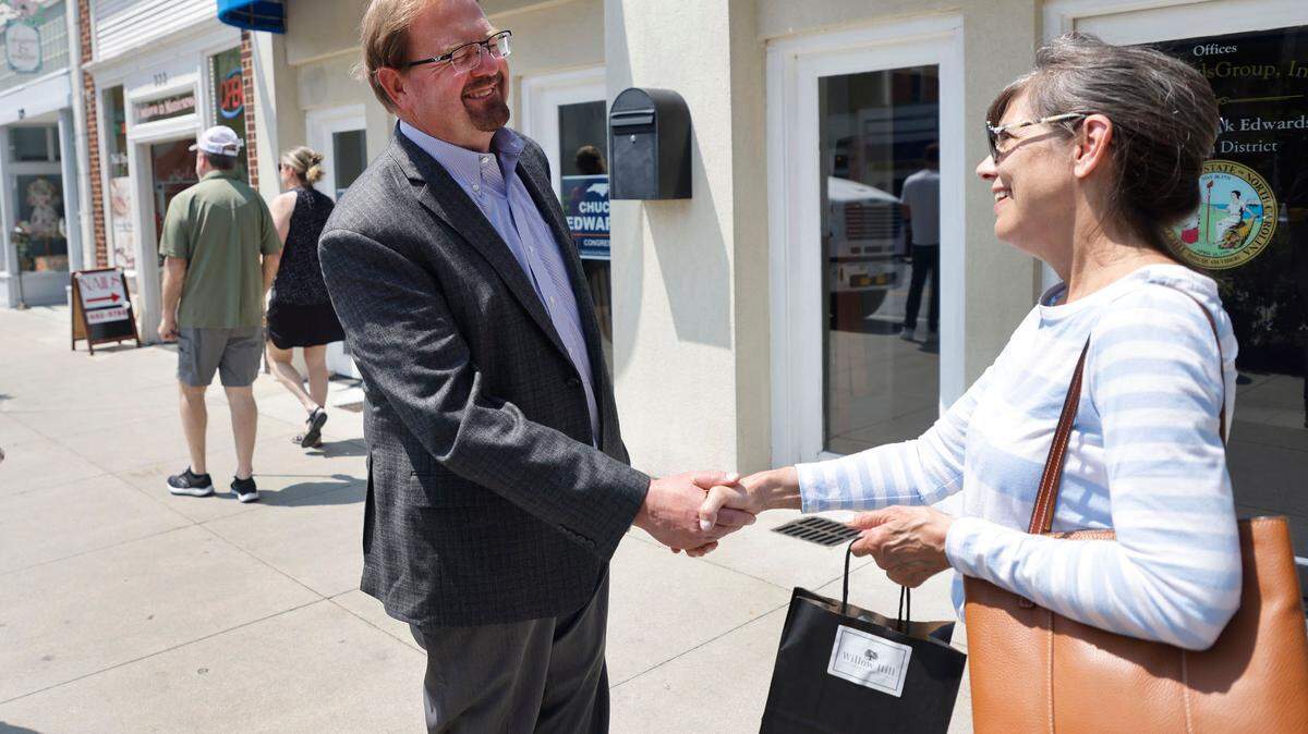 Then-state Sen. Chuck Edwards talks with Denise Engle outside Edwards’ office in Hendersonville, N.C., Wednesday, May 18, 2022.