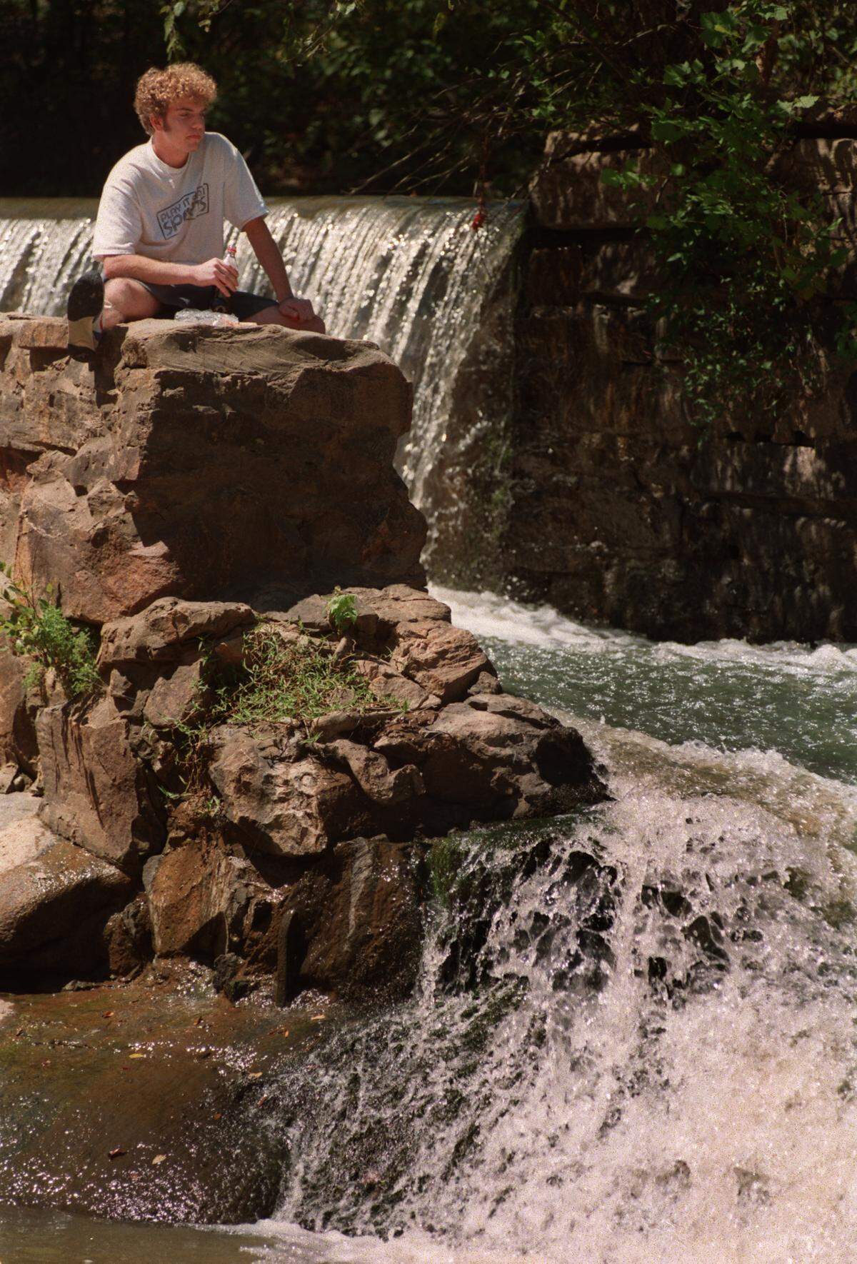 WEATHER.MW.090497.TSS--RALEIGH--Nicholas Farantatos (cq) took advantage of Thursday's beautiful weather to have lunch by the rushing waters of Crabtree Creek at the old Lassiter Mill dam. staff/scott sharpe