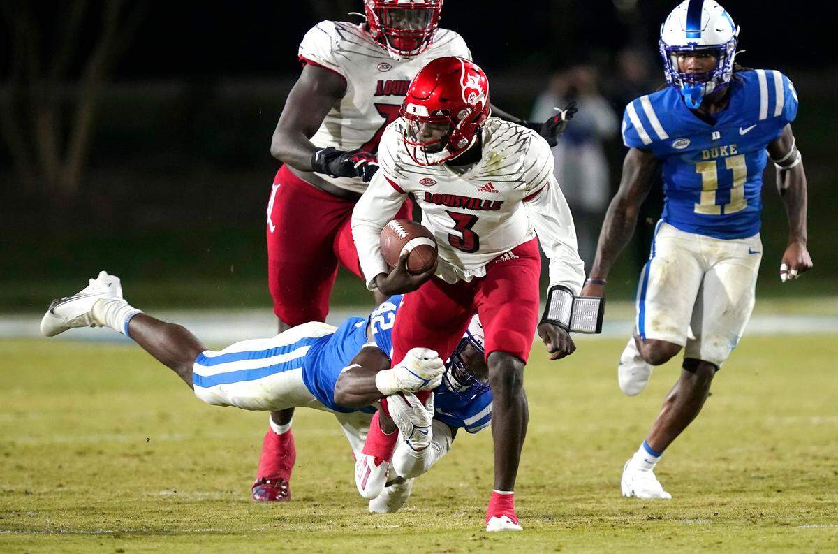 Louisville quarterback Malik Cunningham (3) breaks a tackle against Duke linebacker Shaka Heyward (42) during the first half of an NCAA college football game in Durham, N.C., Thursday, Nov. 18, 2021. Cunningham scored on the play.