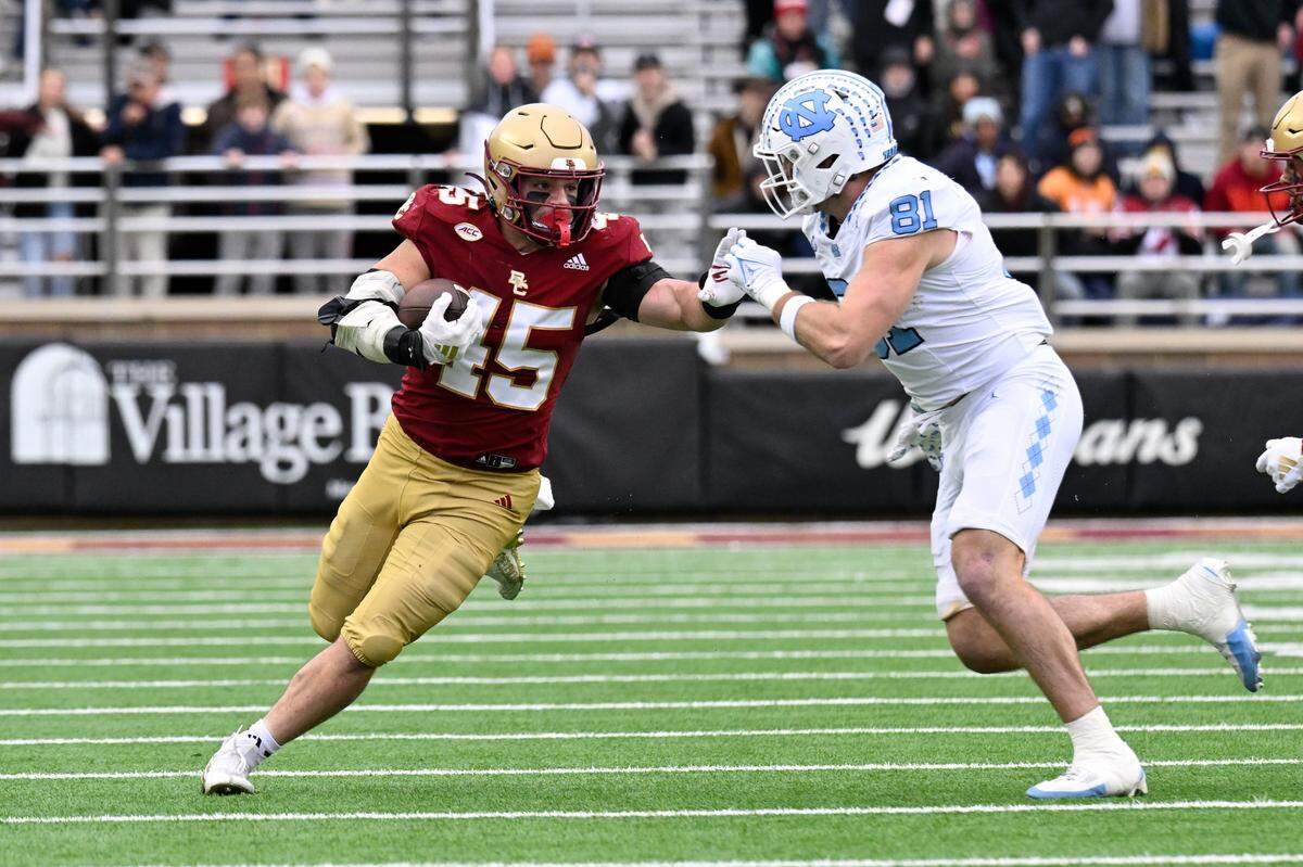 Boston College Eagles linebacker Joe Marinaro (45) runs his interception back against North Carolina Tar Heels tight end John Copenhaver (81) during the first half at Alumni Stadium.