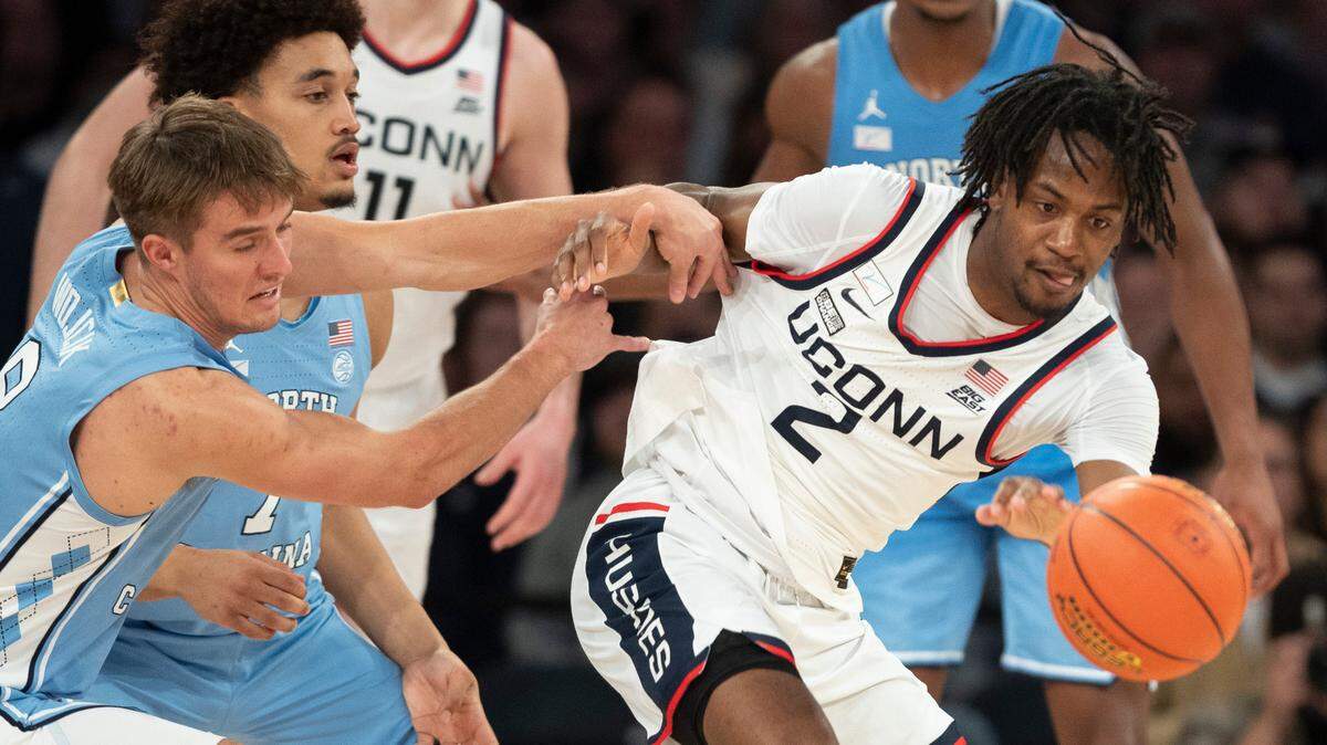 North Carolina’s Paxson Wojcik (8) and Seth Trimble (7) try for a steal from Connecticut’s Tristen Newton (2) during the second half in the Jimmy V Classic on Tuesday, December 5, 2023 at Madison Square Garden in New York, NY.