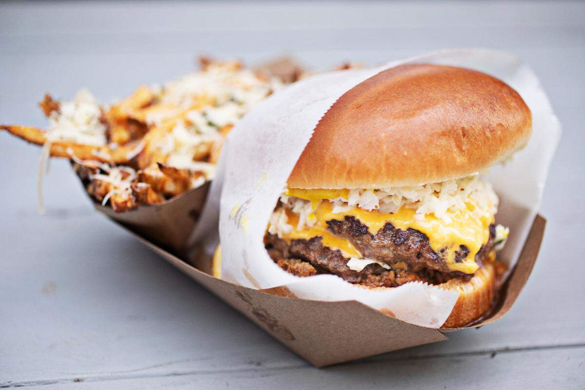The Southern Classic is topped off with chili, cheese, slaw, onion and mustard and served here with a side of Italiano fries at CowBar in Raleigh.