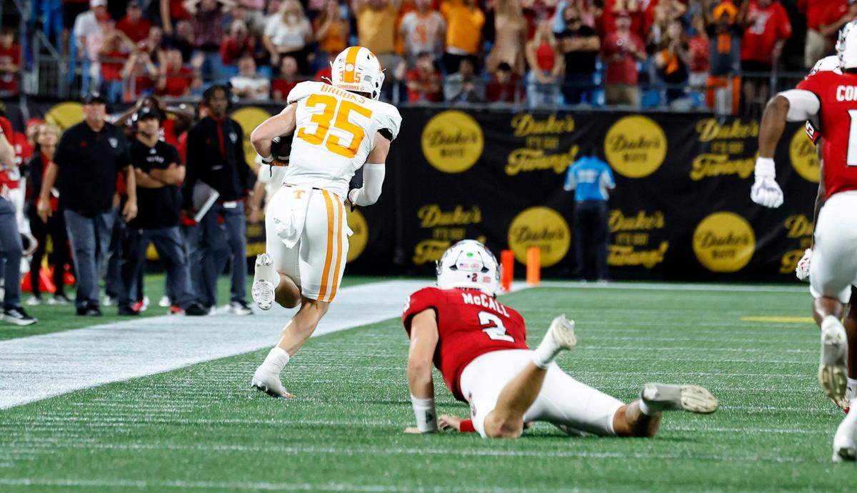 Tennessee’s Will Brooks (35) returns an interception for a touchdown as N.C. State quarterback Grayson McCall (2) watches during the first half of N.C. State’s game against Tennessee in the Duke’s Mayo Classic at Bank of America Stadium in Charlotte, N.C., Saturday, Sept. 7, 2024.