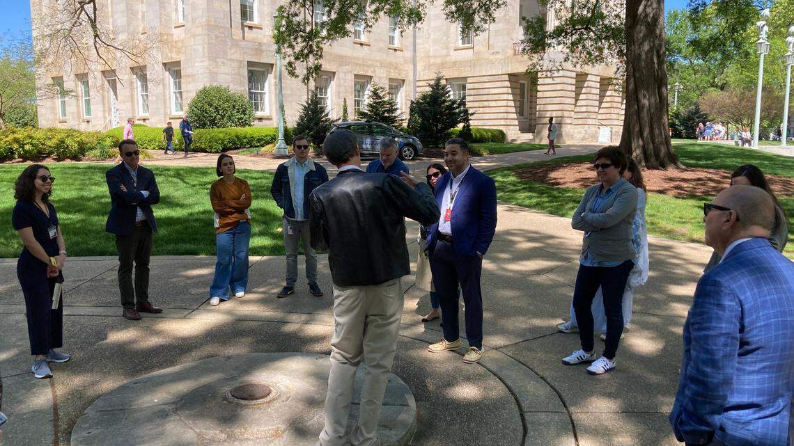 Ernest Dollar, executive director of the City of Raleigh Museum, talks with News & Observer journalists on the State Capitol grounds.