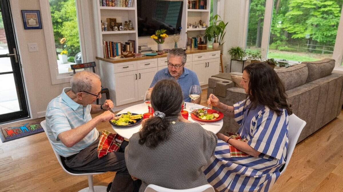 Sara and Lee Stein dine with Sara’s mother and stepfather Abby and Bob Millhauser in their 940 sq ft accessory dwelling unit next to their home at Alloway Court on Friday, April 19, 2024 in Raleigh, N.C. The Milhuasers moved into their new home in January 2024.