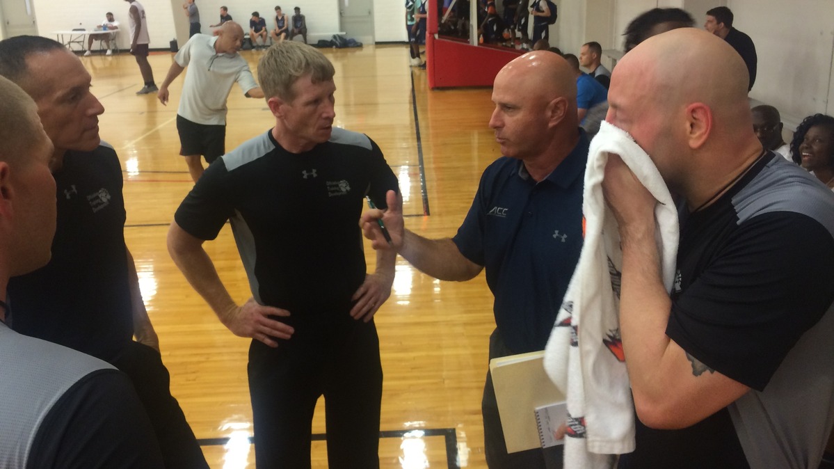 ACC basketball official Tim Comer, second from right, debriefs officiating candidates Brian Damasiewicz, right, Ryan Christian, center, Ty Meixsell, second from left, and Chuck McCoy, left, after a summer camp game Friday at N.C. State's Carmichael Gym.
