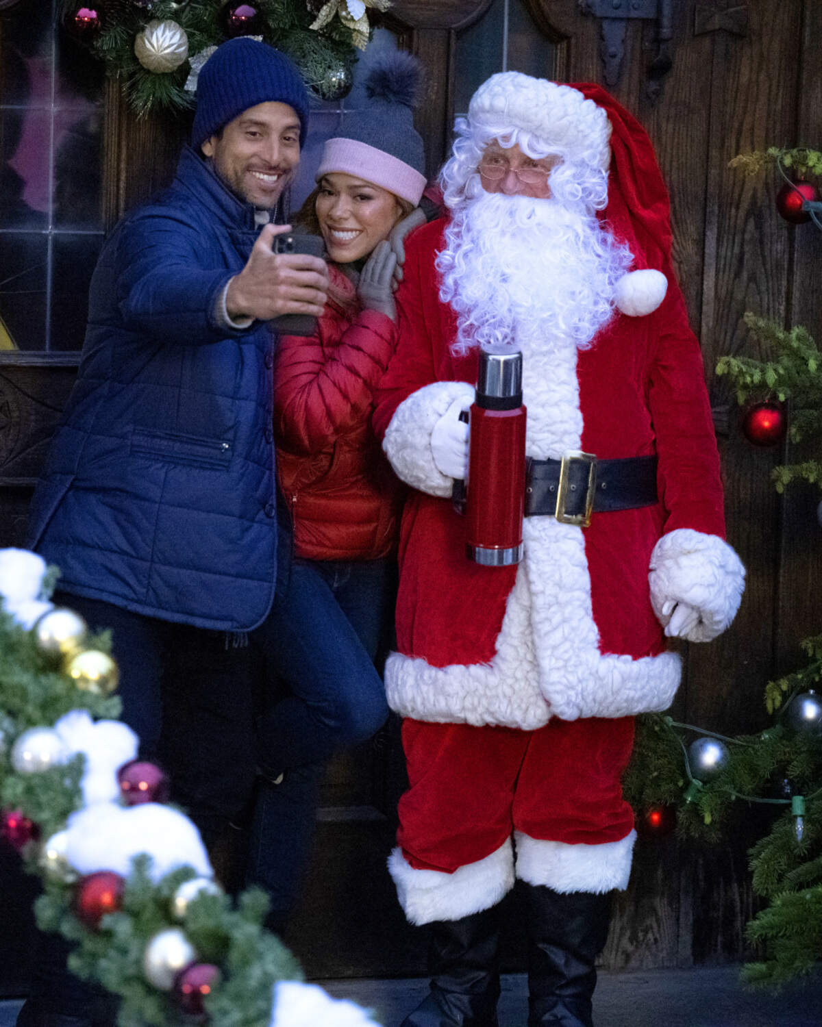 Adam Rodriguez, left, and Jessica Camacho (with Santa Claus) in the CBS original movie “A Christmas Proposal.”
