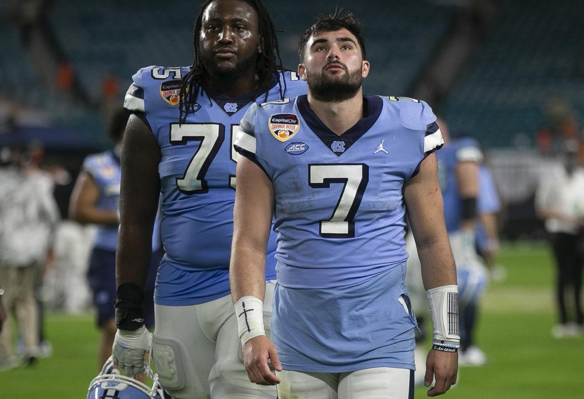 North Carolina’s Joshua Ezeudu (75) and quarterback Sam Howell leave the field following the Tar Heels’ 41-27 loss to Texas A&M in the Capital One Orange Bowl on Saturday, January 2, 2021in Miami Gardens, Florida. 