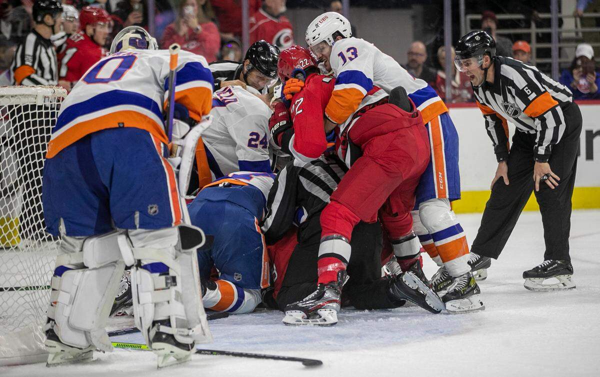 Carolina Hurricanes’ Brett Pesce (22) and New York Islanders’ Matthew Barzal (13) ties each other up during a fight between the two teams at the end of the first period during game two of their Stanley Cup series on Wednesday, April 19, 2023 at PNC Arena in Raleigh, N.C.
