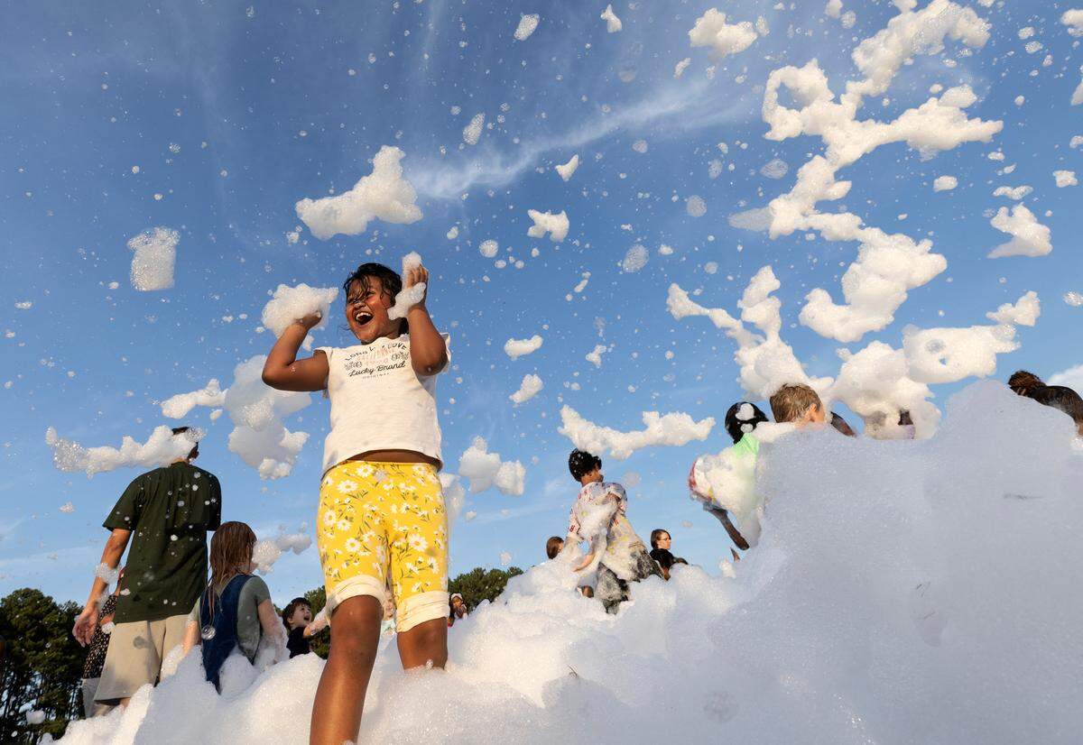 Saanvi Bolledula, 8, delights in a foam pit during an Independence Day celebration at Dorothea Dix Park on Tuesday, July 4, 2023, in Raleigh, N.C.