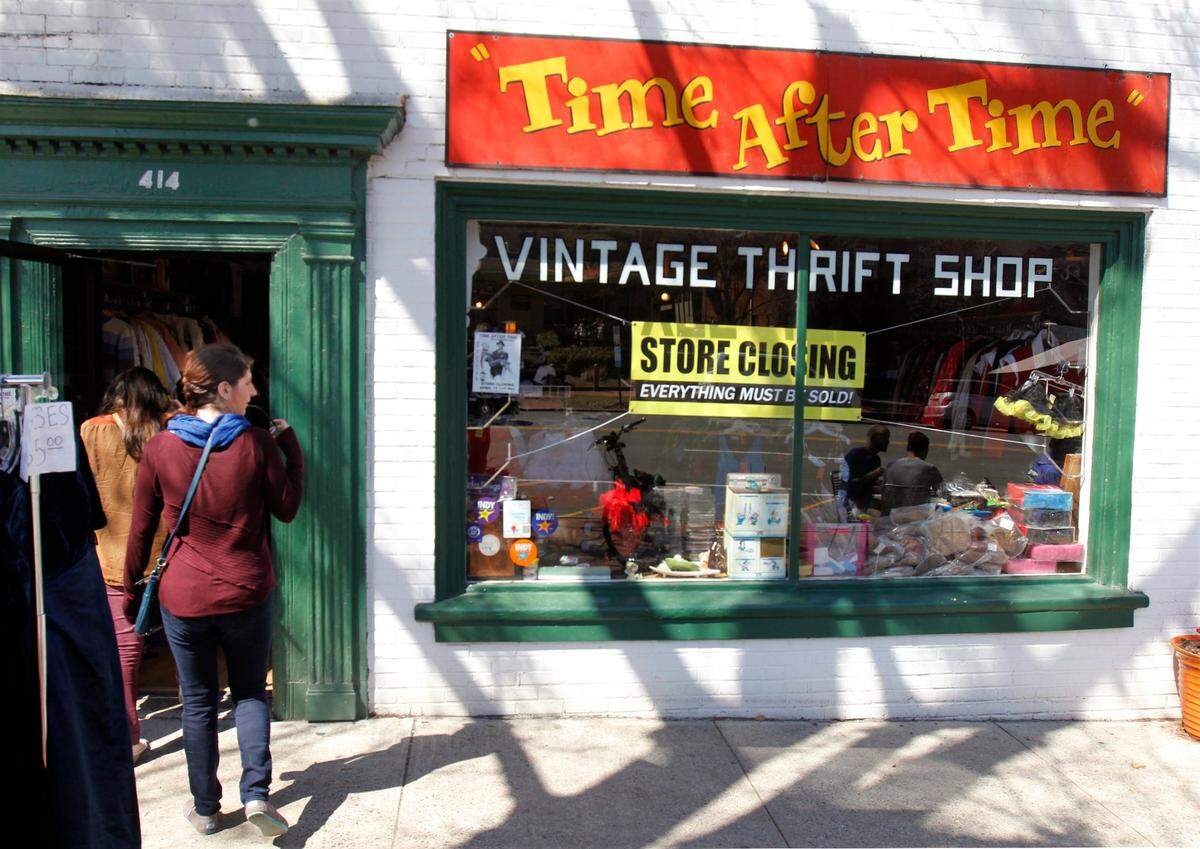 Passerby Elisabeth Albert of Durham, left, checks out the front window as she walks in to the Time After Time vintage thrift shop in the 400 block of W. Franklin St.,March 21, 2014. Store owners Annie Jackson and husband Steven Schrenzel closed their well-known store on April 15, 2014 after more than 30 years in business.