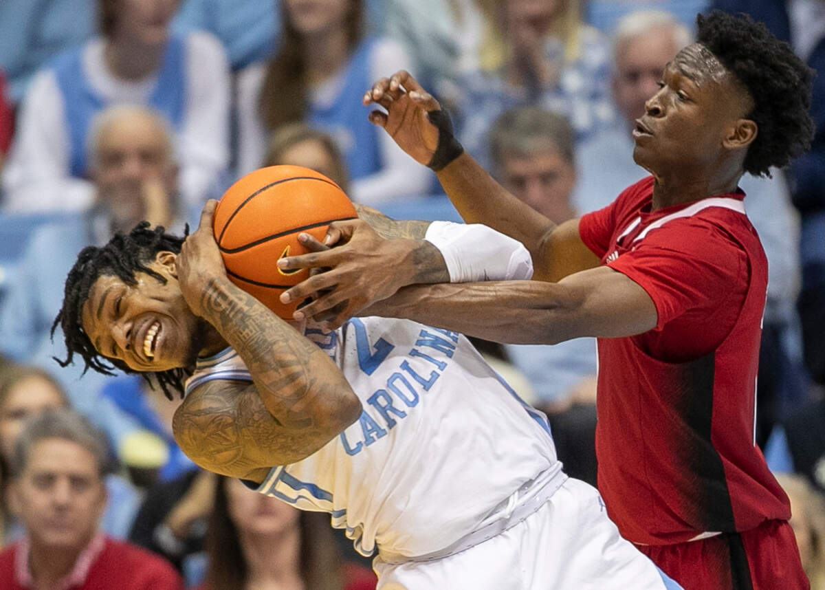 N.C. State’s Jarkel Joiner (1) works to force as turnover by North Carolina’s Caleb Love (2) during the second half on Saturday, January 21, 2023 at the Smith Center in Chapel Hill, N.C.