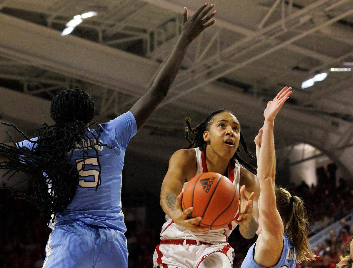 N.C. State’s Aziaha James drives to the basket past North Carolina’s Maria Gakdeng and Lexi Donarski during the second half of the Wolfpack’s 63-59 win on Thursday, Feb. 1, 2024, at Reynolds Coliseum in Raleigh, N.C.