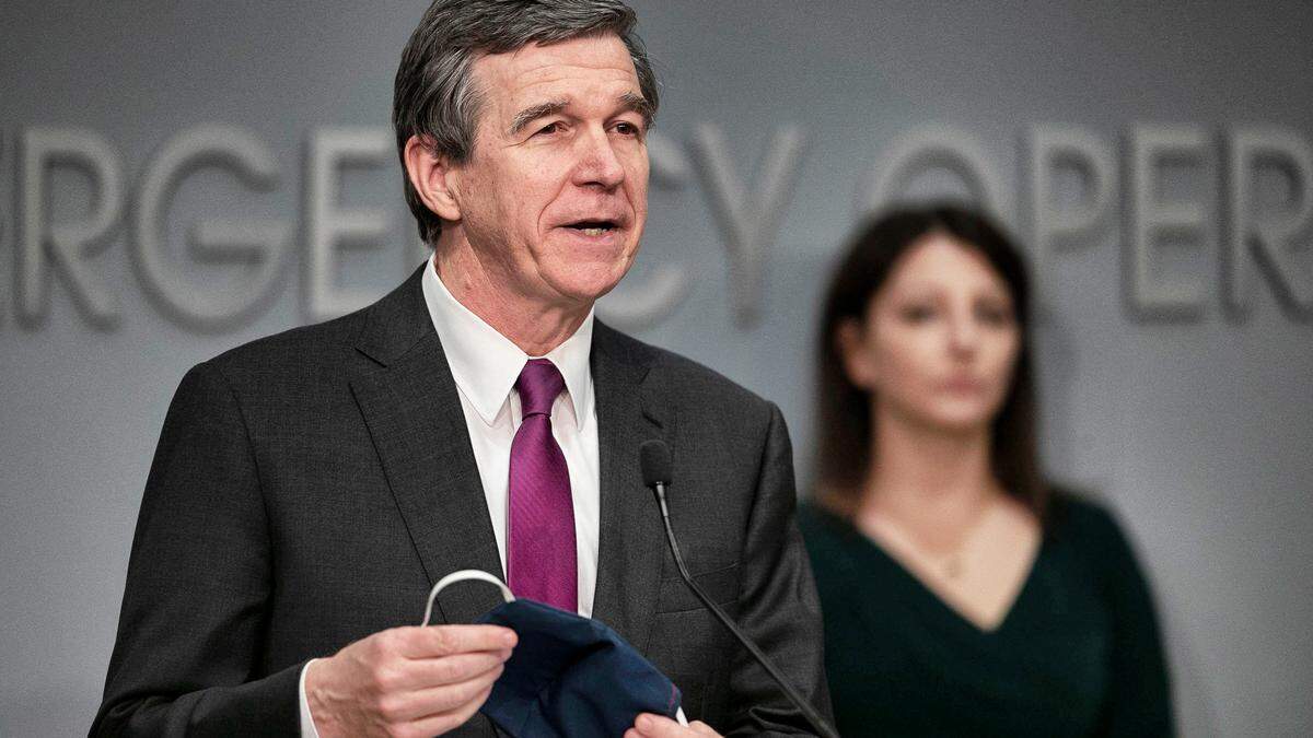 Governor Roy Cooper shows the protective mask he wears, and encourages viewers of his press briefing on the COVID-19 virus to wear one when in public, on Friday, May 8, 2020 at the Emergency Operations Center in Raleigh, N.C.