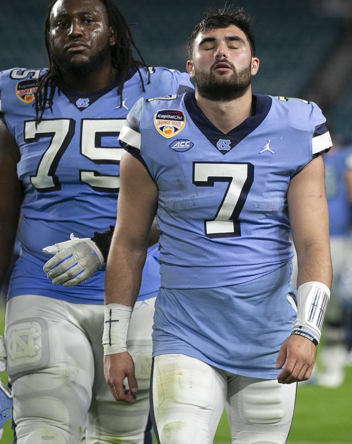 North Carolina’s Joshua Ezeudu (75) and quarterback Sam Howell leave the field following the Tar Heels’ 41-27 loss to Texas A&M in the Capital One Orange Bowl on Saturday, January 2, 2021in Miami Gardens, Florida. 
