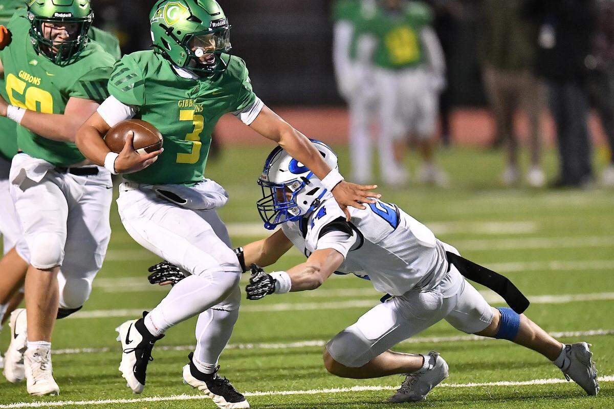 Cardinal Gibbons quarterback Gannon Jones (3) runs for yards against Clayton's Austin Dalton (24) during the second half. The Clayton Comets and the Cardinal Gibbons Crusaders met in the East Regional Final of the NCHSAA 7A Football Championship in Clayton, N.C. on December 4, 2025.