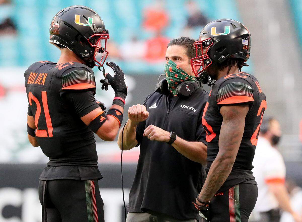 Miami Hurricanes coach Manny Diaz talks with safety Bubba Bolden (21) in the second quarter North Carolina Tar Heels at Hard Rock Stadium In Miami Gardens, Florida, Saturday, December 12, 2020.