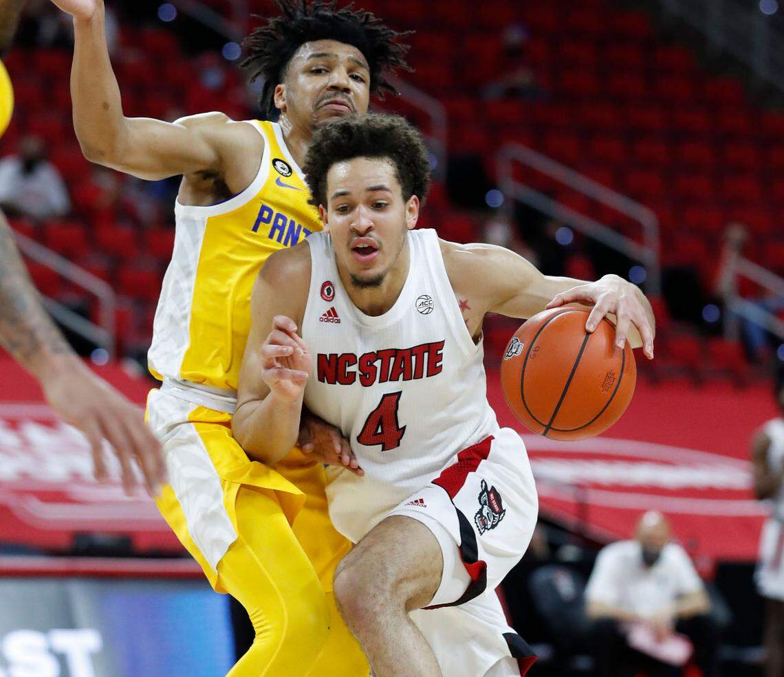 N.C. State’s Jericole Hellems (4) drives by Pittsburgh’s Ithiel Horton (0) during the first half of N.C. State’s game against Pittsburgh at PNC Arena in Raleigh, N.C., Sunday, February 28, 2021.