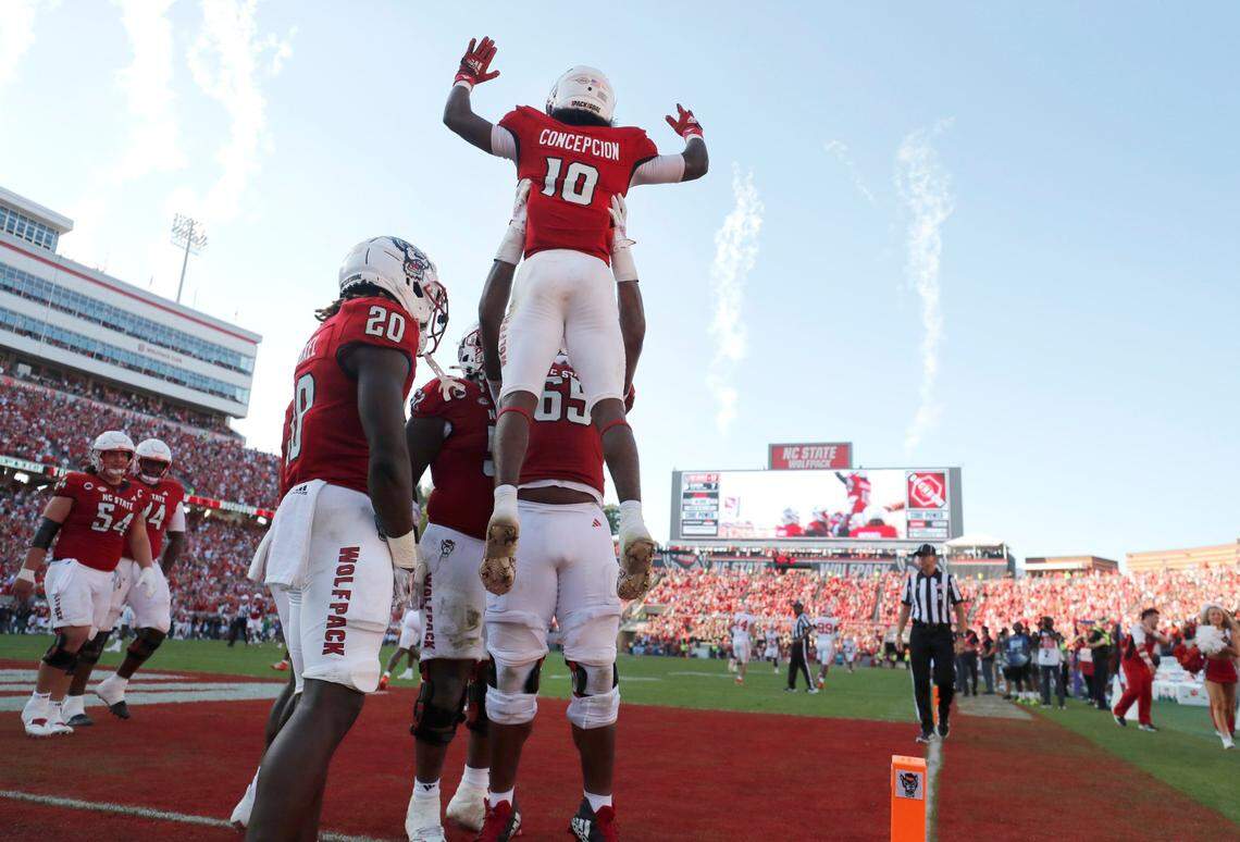 N.C. State offensive lineman Jacarrius Peak (65) lifts up wide receiver KC Concepcion (10) after Concepcion scored on a 72-yard touchdown reception during the second half of N.C. State’s 24-17 victory over Clemson at Carter-Finley Stadium in Raleigh, N.C., Saturday, Oct. 28, 2023.